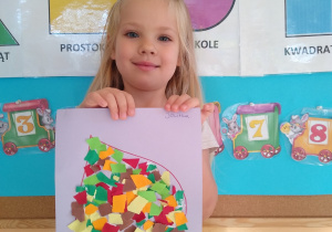 Dziewczynka prezentuje swoją pracę, liść wyklejony wydzieranką z kolorowego papieru