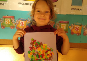 Dziewczynka prezentuje swoją pracę, liść wyklejony wydzieranką z kolorowego