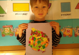 Chłopiec prezentuje swoją pracę, liść wyklejony wydzieranką z kolorowego