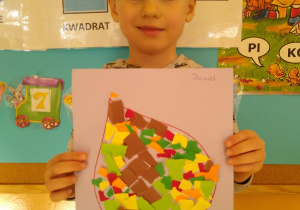 Chłopiec prezentuje swoją pracę, liść wyklejony wydzieranką z kolorowego