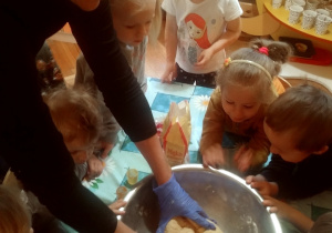 w misce nauczyciel z dziećmi wyrabia masę solną
