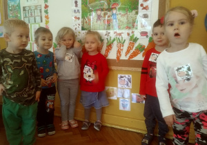 dzieci stoja przy obrazku krówki